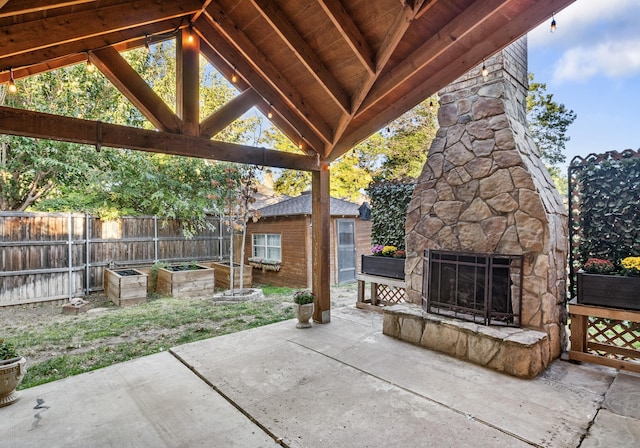 view of patio featuring a gazebo and an outdoor stone fireplace