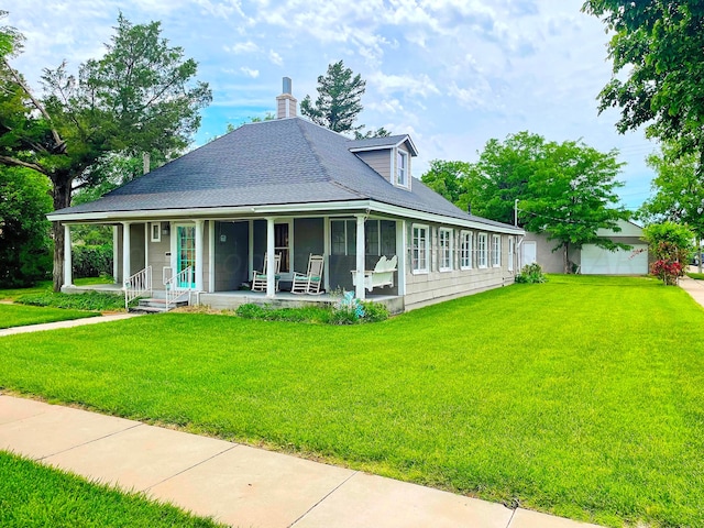 farmhouse-style home with a garage, a front yard, an outdoor structure, and a porch