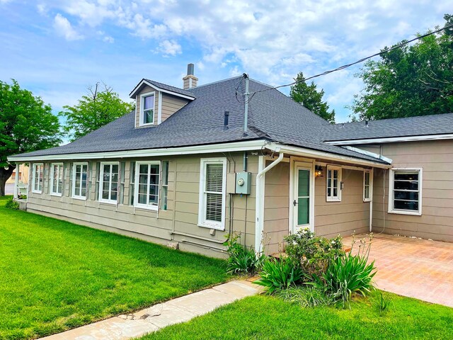 view of front of house with a front yard and a patio