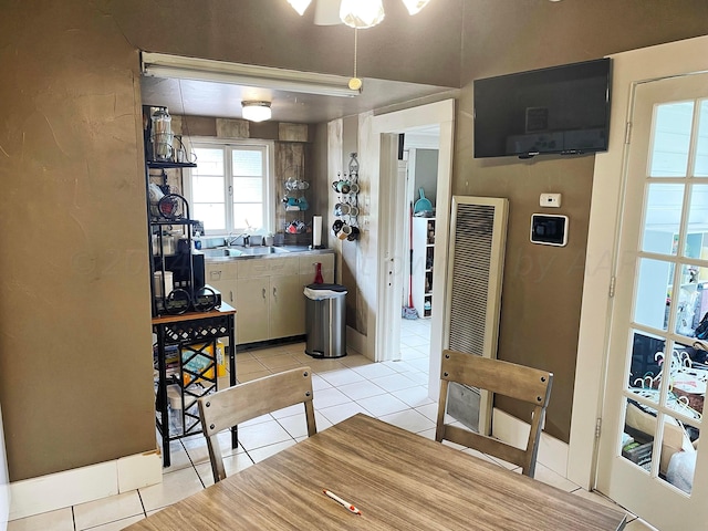 kitchen featuring light tile patterned flooring, white cabinetry, and sink