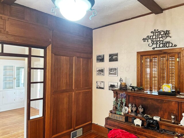 entryway with hardwood / wood-style flooring and beam ceiling