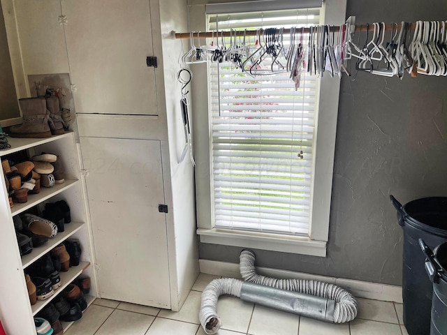 clothes washing area featuring a healthy amount of sunlight and light tile patterned floors