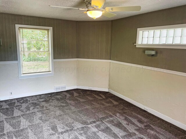 carpeted empty room with a textured ceiling and ceiling fan