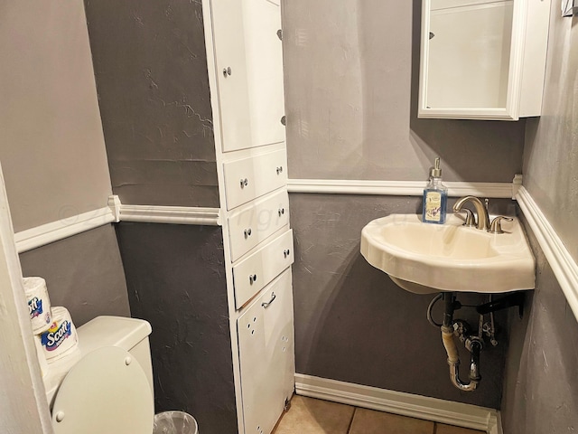 bathroom featuring tile patterned flooring, toilet, and sink