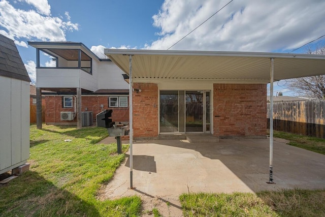 back of property featuring a patio, brick siding, fence, and central AC unit