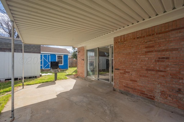 view of patio / terrace featuring a storage shed, an outbuilding, and fence