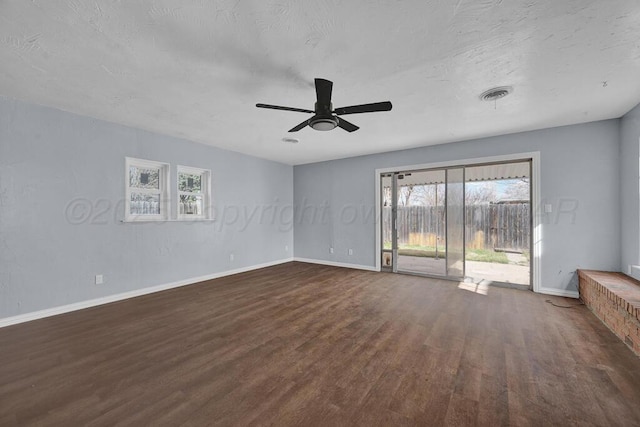 interior space with dark wood-style flooring, baseboards, a ceiling fan, and visible vents