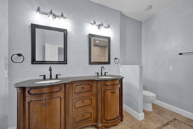 full bathroom featuring a sink, toilet, double vanity, and baseboards