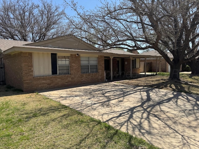 rear view of property with brick siding, a porch, and a lawn