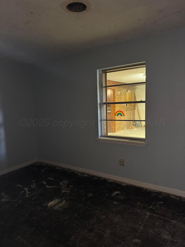 unfurnished room with baseboards