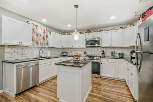 4639 S Hughes St, Amarillo, TX 79110 - kitchen with stainless steel appliances, a center island, white cabinetry, light wood finished floors, and recessed lighting