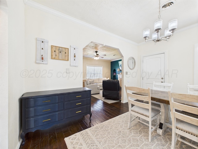 1206 N Russell St, Pampa, TX 79065 - dining space featuring ornamental molding, dark wood-style floors, a chandelier, arched walkways, and a ceiling fan
