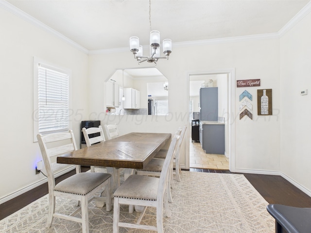 1206 N Russell St, Pampa, TX 79065 - dining space featuring a chandelier, ornamental molding, baseboards, arched walkways, and wood finished floors