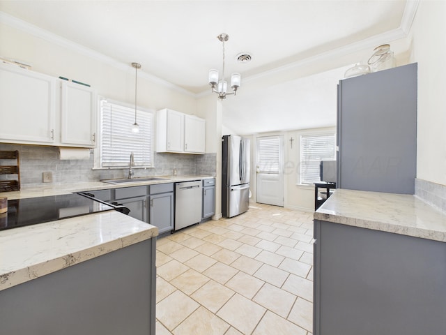 1206 N Russell St, Pampa, TX 79065 - kitchen with a sink, stainless steel appliances, backsplash, ornamental molding, and a chandelier
