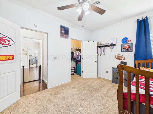 1206 N Russell St, Pampa, TX 79065 - bedroom with ornamental molding, carpet, a walk in closet, baseboards, and ceiling fan