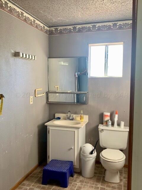 bathroom featuring vanity, a textured ceiling, and toilet