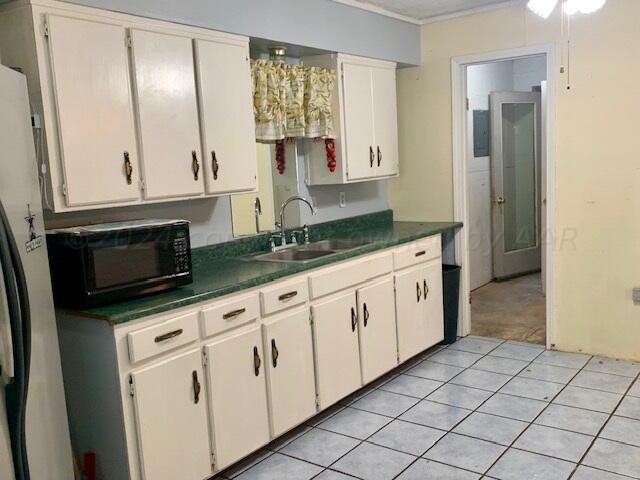 kitchen featuring white cabinetry, sink, ceiling fan, and light tile patterned flooring