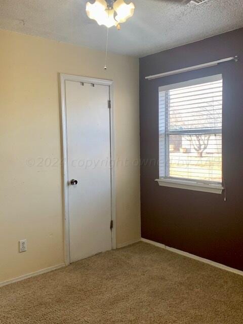 carpeted spare room with a textured ceiling