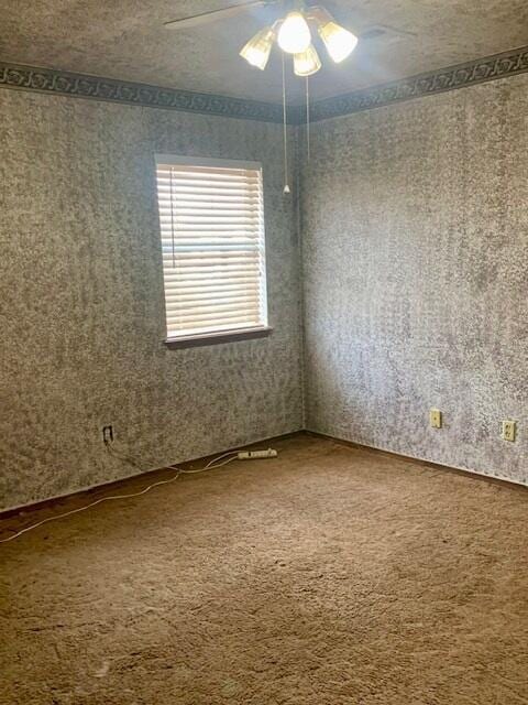 carpeted empty room with a textured ceiling and ceiling fan