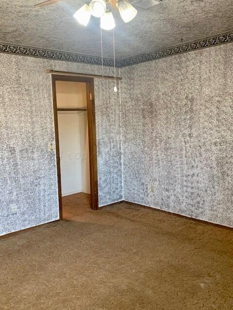 unfurnished bedroom featuring ceiling fan, a textured ceiling, and carpet floors