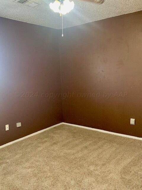 carpeted spare room with a textured ceiling and ceiling fan