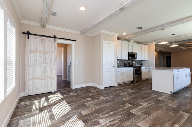 kitchen with light stone counters, white cabinets, a barn door, pendant lighting, and appliances with stainless steel finishes