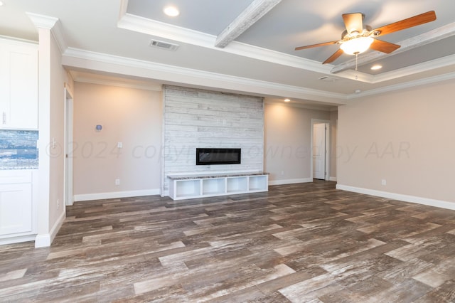 unfurnished living room with ceiling fan, a raised ceiling, ornamental molding, and dark hardwood / wood-style floors