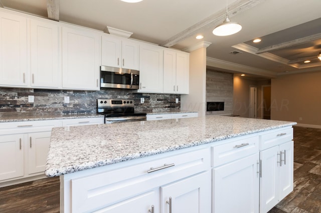 kitchen with stainless steel appliances, white cabinets, and pendant lighting