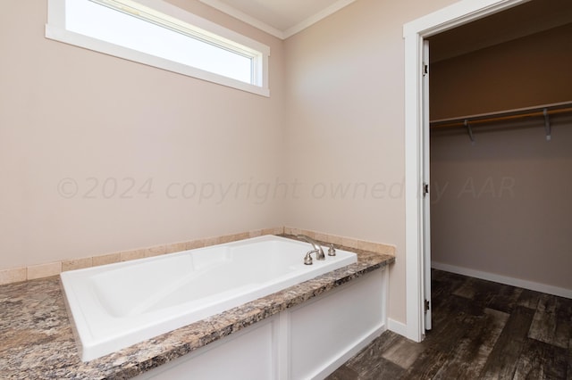 bathroom featuring hardwood / wood-style floors, a bath, and crown molding