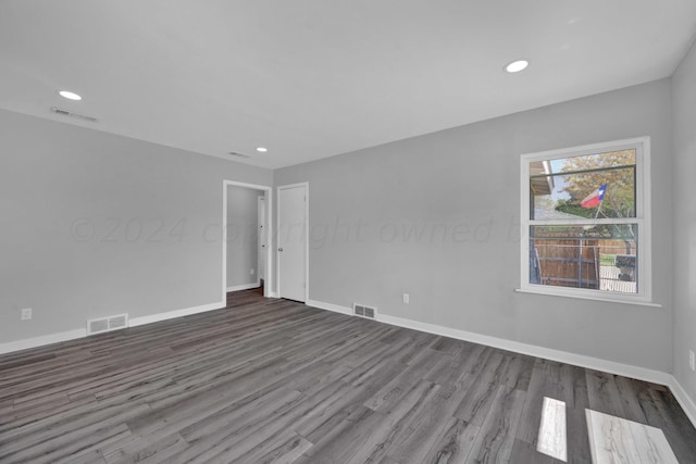 unfurnished room with baseboards, visible vents, and wood finished floors