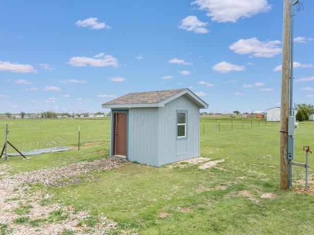 view of shed featuring fence and a rural view