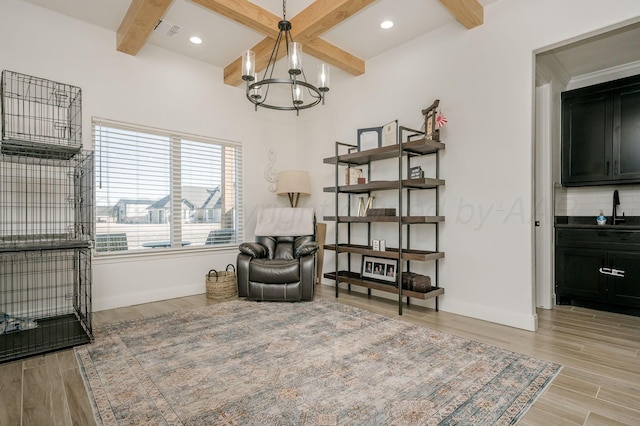 sitting room with baseboards, beamed ceiling, an inviting chandelier, light wood-style floors, and recessed lighting