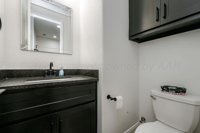 half bathroom featuring toilet and vanity