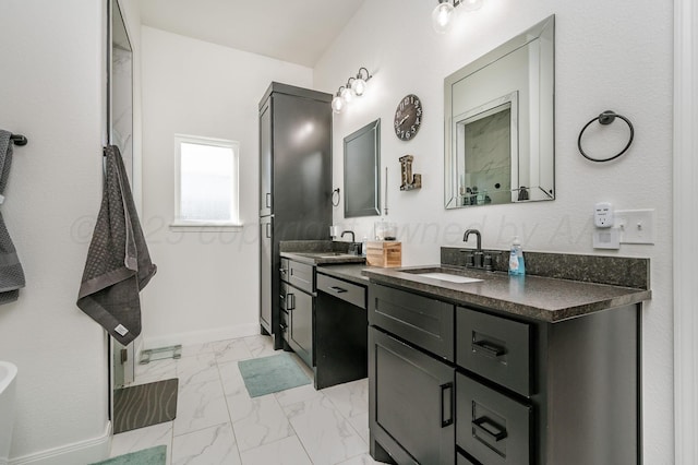 bathroom featuring double vanity, marble finish floor, baseboards, and a sink