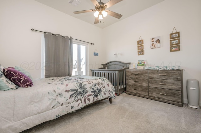 bedroom with light carpet, visible vents, and a ceiling fan