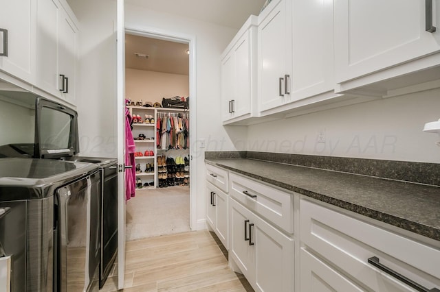 kitchen featuring light wood-style flooring, visible vents, white cabinetry, and separate washer and dryer