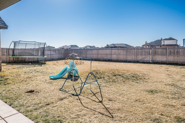 view of yard with a trampoline and a fenced backyard