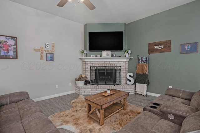 living room with ceiling fan, a fireplace, and hardwood / wood-style flooring