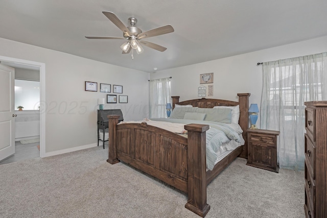 bedroom featuring light carpet, ceiling fan, and ensuite bathroom