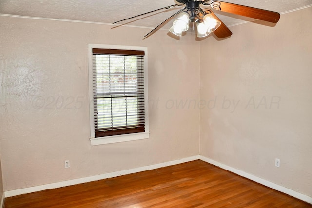 unfurnished room with ornamental molding, wood finished floors, ceiling fan, and baseboards