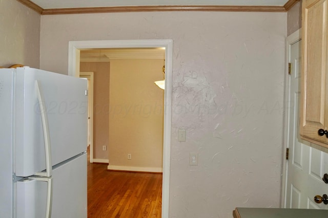 kitchen with freestanding refrigerator, dark wood finished floors, ornamental molding, and baseboards