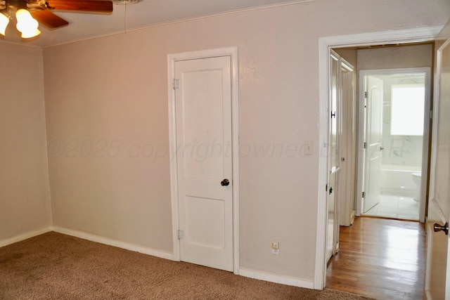 unfurnished bedroom with attic access, baseboards, and carpet floors