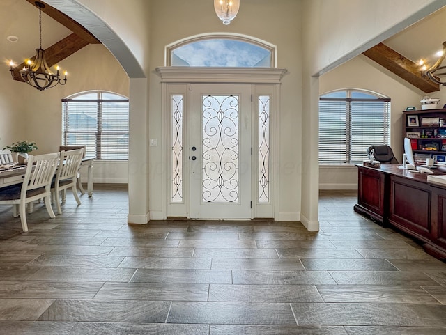 entryway featuring beamed ceiling and a chandelier