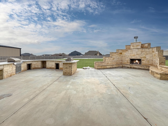 view of patio / terrace featuring an outdoor kitchen, grilling area, and an outdoor stone fireplace