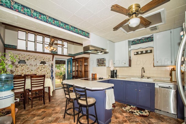 kitchen featuring dishwasher, sink, a breakfast bar area, kitchen peninsula, and blue cabinetry