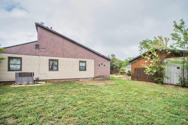 back of house featuring a yard and central air condition unit