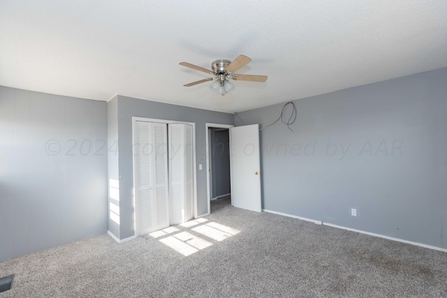 unfurnished bedroom featuring ceiling fan, carpet flooring, and a closet