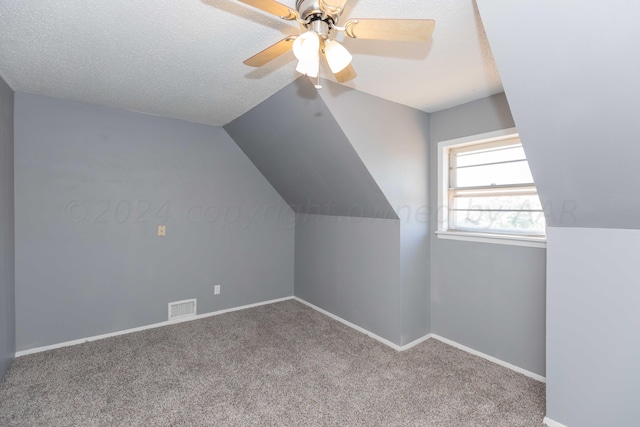 additional living space featuring ceiling fan, a textured ceiling, lofted ceiling, and carpet