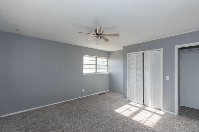 unfurnished bedroom with carpet, a textured ceiling, and ceiling fan