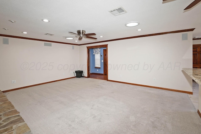 carpeted empty room featuring a textured ceiling, ornamental molding, and ceiling fan